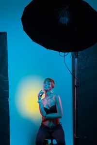 A white 4ft umbrella as key light and 2x 4ft silver umbrellas used as rim lighting - all with coloured gels